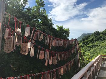 Low angle view of clothes hanging on railing against sky