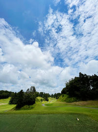 Scenic view of golf course against sky