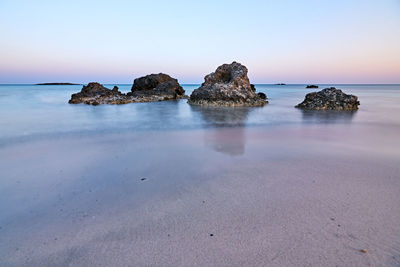 Rocks on beach against sky