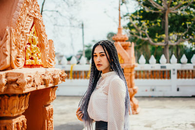 Portrait of young woman standing outdoors