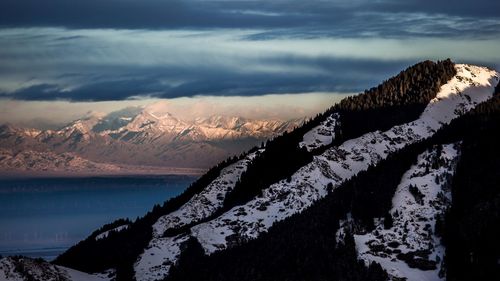 Scenic view of sea and mountains against sky