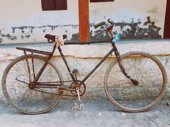 Rusty bicycle against wall