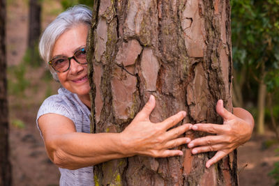 Portrait of smiling woman with tree trunk