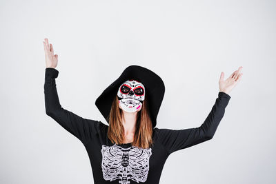 Portrait of young woman standing against white background