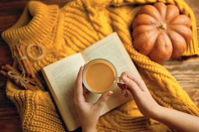 Midsection of woman holding coffee cup on table