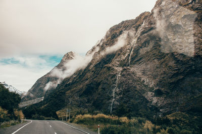 Road by mountain against sky