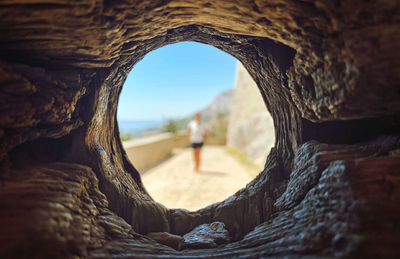 View of man seen through hole against sky