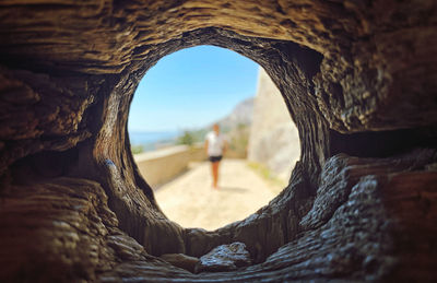 Rear view of woman standing on rock