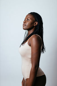 Side view of young woman against white background