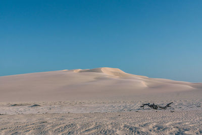 Sand dunes in desert against clear blue sky