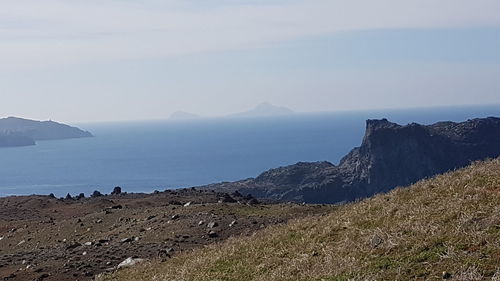 Scenic view of sea and mountains against sky