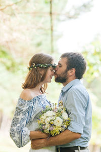 Young couple standing against blue sky