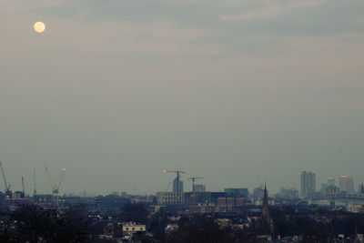 Aerial view of buildings in city against sky at sunset