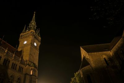 Low angle view of clock tower at night