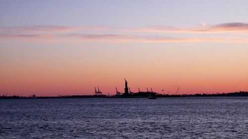 Silhouette ship in sea against sky during sunset