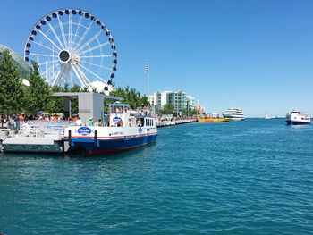 Ferris wheel in city against clear blue sky