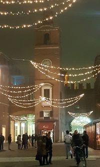 People in illuminated christmas lights at night