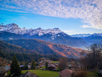 Scenic view of townscape and mountains against sky