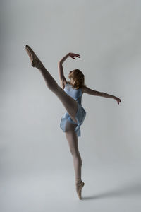 Ballet dancing against gray background