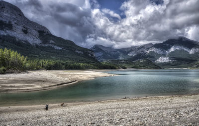 Scenic view of lake by mountains against sky