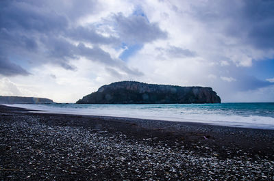 View of beach against cloudy sky