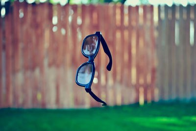 Eyeglasses levitating over grassy field