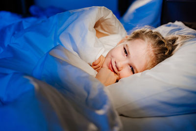 Boy sleeping on bed at home