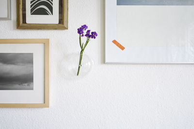 White flower vase on table against wall at home