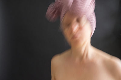 Close-up of shirtless woman against black background