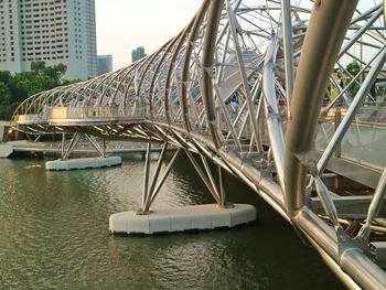 Bridge over river against buildings in singapore 