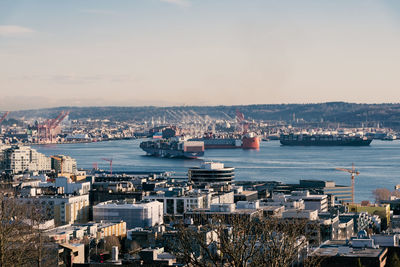 High angle view of cityscape and sea against sky