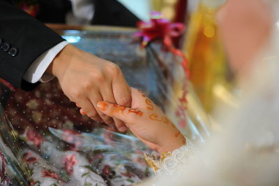 Close-up of bride and groom holding hands