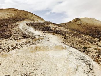 Scenic view of sand dunes against sky