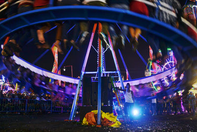 People at amusement park ride at night