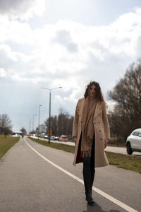 Woman standing on road against sky