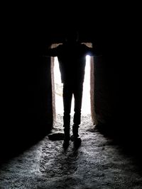 Rear view of silhouette woman standing in illuminated corridor