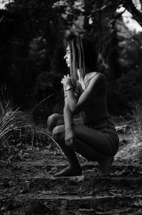 Side view of woman crouching on steps