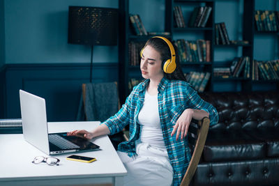 Beautiful woman using laptop while sitting at home