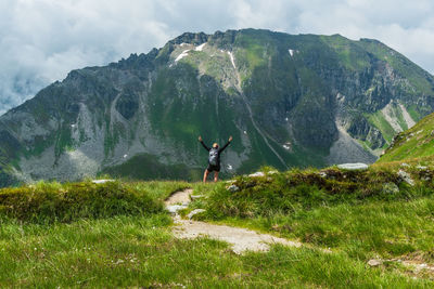 Rear view of person on mountain against sky
