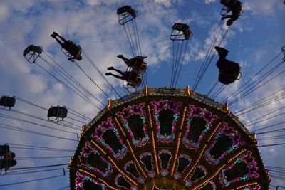 Low angle view of chain swing ride against sky