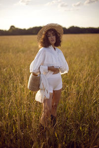  portrait of a curly-haired woman in white clothes and in a wicker hat and with a basket in autumn