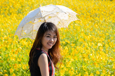 Portrait of smiling woman standing in rain during rainy season