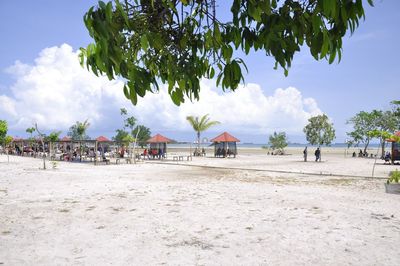 Panoramic view of people on beach against sky