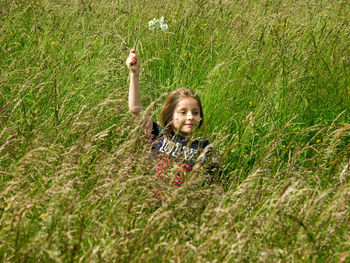 Portrait of smiling girl holding green plants