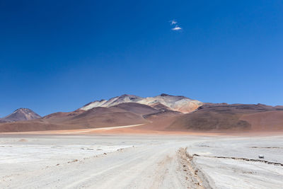 Dirt road with colourful mountains in the background, eduardo avaroa andean fauna national reserve