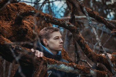 Portrait of young man looking away in forest