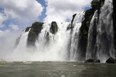 Scenic view of waterfall against sky