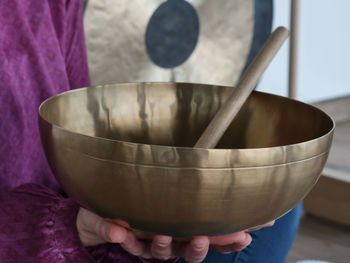 Midsection of woman holding prayer bowl