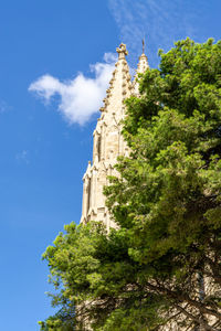Low angle view of trees and building against sky