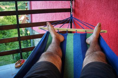 Low section of man relaxing on hammock